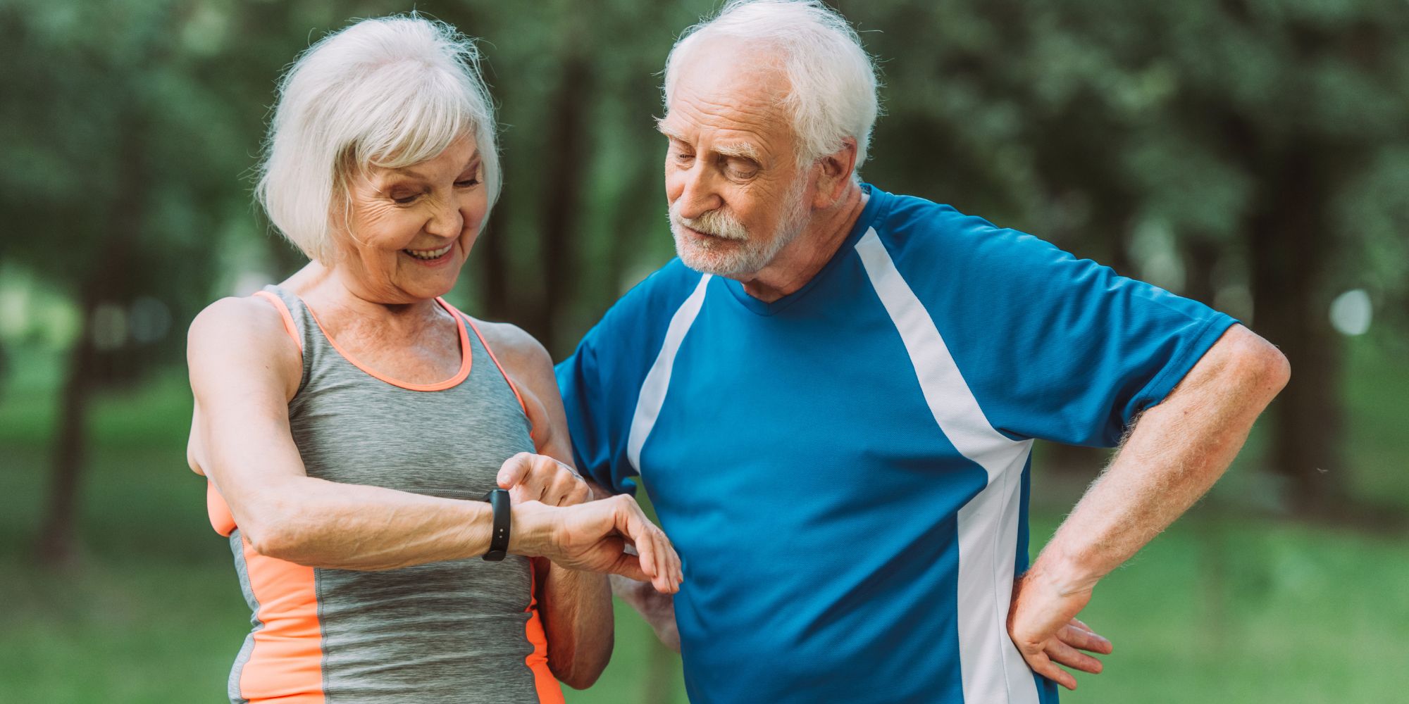 senior couple looking at a fitness tracker top fitness trackers for seniors